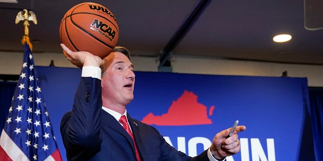 Virginia Gov.-elect Glenn Youngkin tosses a signed basketball to supporters at an election night party in Chantilly, Va., early Wednesday, Nov. 3, 2021, after he defeated Democrat Terry McAuliffe. (AP Photo/Andrew Harnik)