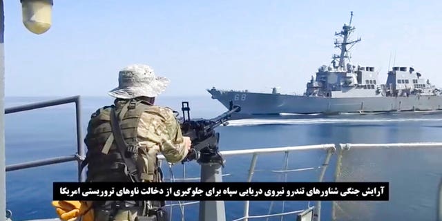 Cette capture d'écran d'une vidéo publiée par les Gardiens de la révolution paramilitaires iraniens le mercredi 3 novembre 2021, montre un soldat de la Garde sur un hors-bord devant un navire de guerre américain lors de la saisie d'un pétrolier battant pavillon vietnamien dans le golfe d'Oman .  L'Iran a saisi le pétrolier dans le golfe d'Oman le mois dernier et détient toujours le navire, ont déclaré mercredi deux responsables américains à l'Associated Press, révélant la dernière provocation dans les eaux du Moyen-Orient alors que les tensions s'intensifient entre l'Iran et les États-Unis au sujet du programme nucléaire de Téhéran.  (Garde révolutionnaire via AP)