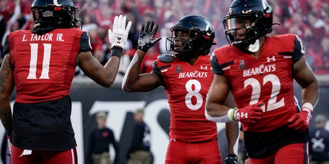 Cincinnati wide receiver Michael Young Jr. (8) celebrates with tight end Leonard Taylor (11) after scoring a touchdown during the second half of an NCAA college football game against Tulsa Saturday, Nov. 6, 2021, in Cincinnati. (AP Photo/Jeff Dean)