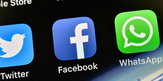 FILE - The icons of Facebook and WhatsApp are seen on an iPhone in Gelsenkirchen, Germany, Nov. 15, 2018. 