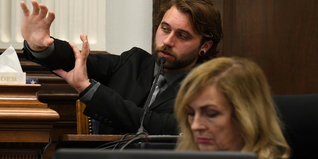 Gaige Grosskreutz talks about the permanent injuries to his right arm and hand as he testifies about being shot, during the Kyle Rittenhouse trial at the Kenosha County Courthouse in Kenosha, Wis., on Monday, Nov. 8, 2021. (Mark Hertzberg/Pool Photo via AP)