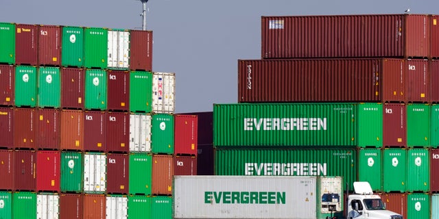 Shipping containers are stacked over a truck at the Port of Los Angeles Wednesday, Nov. 10, 2021, in Los Angeles.