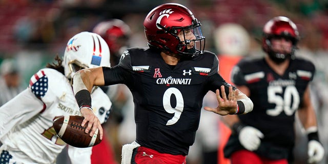 Cincinnati quarterback Desmond Ridder (9) looks to pass as he rolls out against South Florida during the first half of an NCAA college football game Friday, Nov. 12, 2021, in Tampa, Fla.