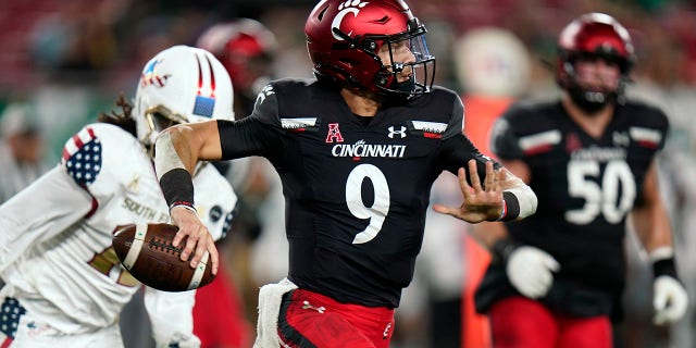 Cincinnati quarterback Desmond Ridder (9) looks to pass as he rolls out against South Florida during the first half of an NCAA college football game Friday, Nov. 12, 2021, in Tampa, Fla.