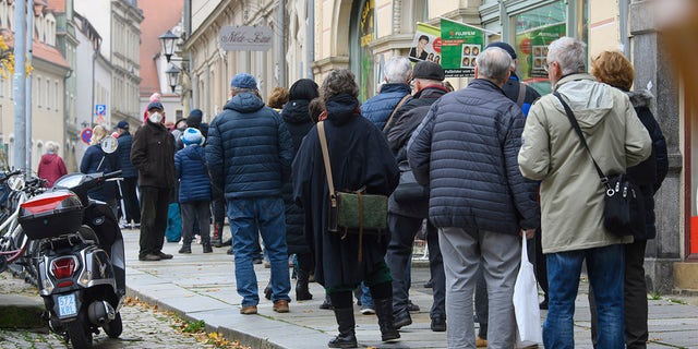 Des personnes font la queue pour se faire vacciner contre le coronavirus lors d'une campagne de vaccination de la DRK, Croix-Rouge allemande, devant la mairie de Pirna, en Allemagne, le lundi 15 novembre 2021. 