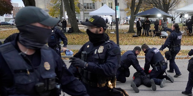 A protester is taken into custody by police outside the Kenosha County Courthouse, Wednesday, Nov. 17, 2021 in Kenosha, Wis., during the Kyle Rittenhouse murder trial. (AP Photo/Paul Sancya)