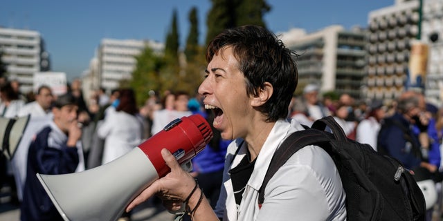 FILE - Healthcare workers opposing mandatory coronavirus vaccinations and the suspension from work for those who refuse to get the shots, chant slogans during a protest outside the Greek Parliament , in central Athens, on Wednesday, Nov 3, 2021. (AP Photo/Petros Giannakouris, File)