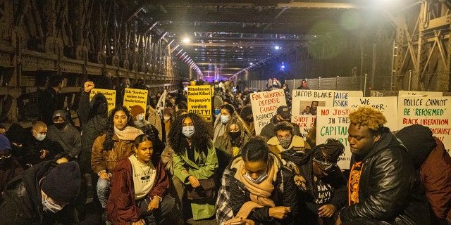 Protests kneel on the Brooklyn Bridge in New York City on Friday night.