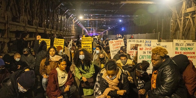 Protests kneel on the Brooklyn Bridge in New York City on Friday night. 