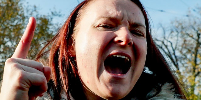 A woman takes part in a demonstration against the country's coronavirus restrictions in Vienna, Austria, Saturday, Nov.20, 2021. Thousands of protesters are expected to gather in Vienna after the Austrian government announced a nationwide lockdown to contain the quickly rising coronavirus infections in the country. (AP Photo/Lisa Leutner)