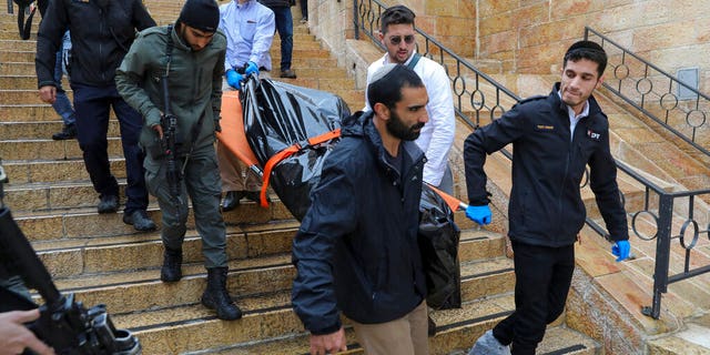 Israeli security personnel and members of Zaka Rescue and Recovery team carry the body of a Palestinian man who was fatally shot by Israeli police after he killed one Israeli and wounded four others in a shooting attack in Jerusalem's Old City, Sunday, Nov. 21, 2021. (AP Photo/Mahmoud Illean)