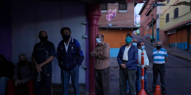 Venezuelans line up to vote during regional elections, at a polling station in Caracas, Venezuela, Sunday, Nov. 21, 2021. Venezuelans go to the polls to elect state governors and other local officials. (AP Photo/Ariana Cubillos)