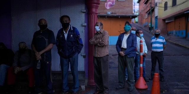 Venezuelans line up to vote during regional elections, at a polling station in Caracas, Venezuela, Sunday, Nov. 21, 2021. Venezuelans go to the polls to elect state governors and other local officials. (AP Photo/Ariana Cubillos)