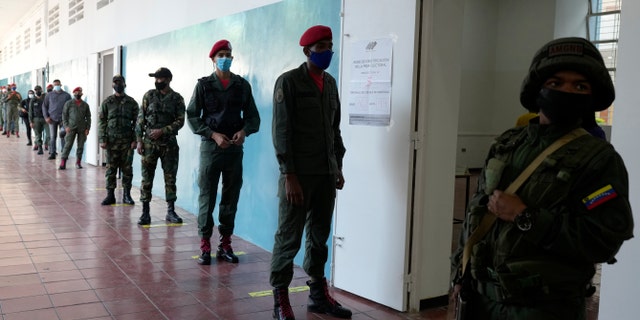 Soldiers line up to vote during regional elections, at a polling station in Caracas, Venezuela, Sunday, Nov. 21, 2021. Venezuelans go to the polls to elect state governors and other local officials. (AP Photo/Ariana Cubillos)