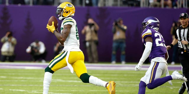 O recebedor branco do Green Bay Packers, Marquez Valdes-Scandling, pegou um passe para touchdown de 75 jardas na frente de Xavier Woods, guarda livre do Minnesota Vikings, no domingo, 21 de novembro de 2021 em Minneapolis.