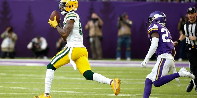 O recebedor branco do Green Bay Packers, Marquez Valdes-Scandling, pegou um passe para touchdown de 75 jardas na frente de Xavier Woods, guarda livre do Minnesota Vikings, no domingo, 21 de novembro de 2021 em Minneapolis.