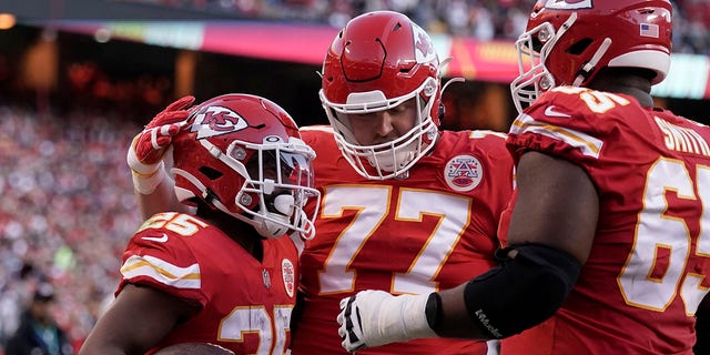 Kansas City Chiefs running back Clyde Edwards-Helaire, left, is congratulated by Andrew Wylie (77) and Trey Smith (65) after scoring during the first half against the Dallas Cowboys Sunday, Nov. 21, 2021, in Kansas City, Mo.