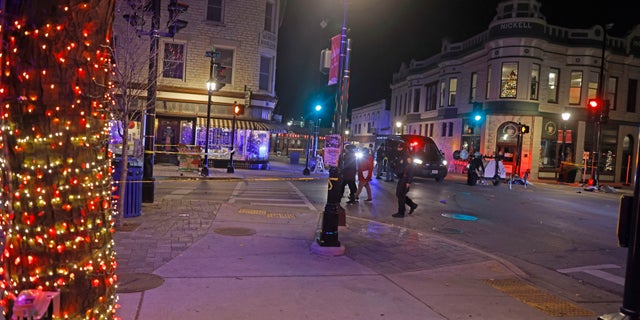 Police canvass the streets in downtown Waukesha, Wis., after a vehicle plowed into a Christmas parade hitting more than 20 people Sunday, Nov. 21, 2021.