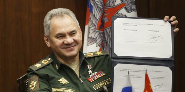 Russian Defense Minister Sergei Shoigu shows his signature under a roadmap for military cooperation between Russia and China during a  call with Chinese Defense Minister Wei Fenghe in Moscow, Russia, Tuesday, Nov. 23, 2021. 