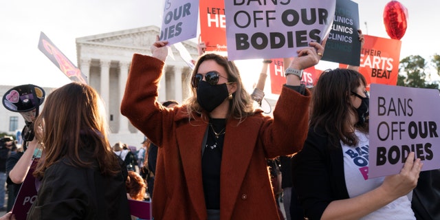FILE - Emily Halvorson, center, of Washington, with Planned Parenthood, joins groups of abortion-rights and anti-abortion activists as they rally outside the Supreme Court, on, Nov. 1, 2021, as arguments are set to begin about abortion by the court, on Capitol Hill in Washington. (AP Photo/Jacquelyn Martin, File)