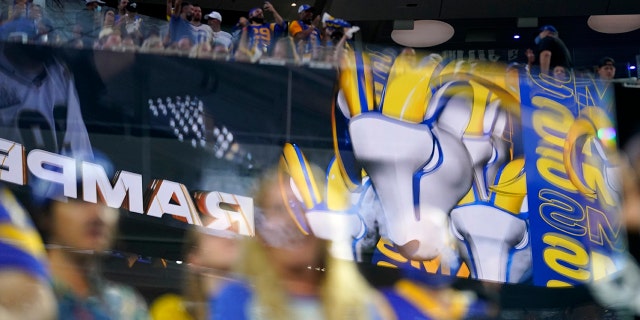 FILE - Fans are seen behind logos from the Los Angeles Rams at SoFi stadium during the first half of an NFL football game against the Chicago Bears, Sept. 12, 2021, in Inglewood, Calif.