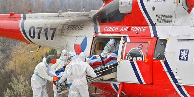 Health workers at the Motol University Hospital take out of army helicopter one of the patients with COVID-19, who was transported to Prague from a hospital in Brno, Czech Republic, Thursday, Nov. 25, 2021. COVID spread reaches another record in Czech Republic, with 27,717 new confirmed COVID cases on Thursday, another daily maximum since the start of the epidemic. (Vit Simanek / CTK via AP)