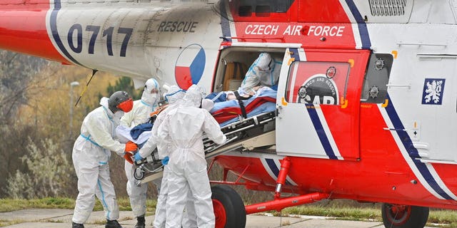 Health workers at the Motol University Hospital take out of army helicopter one of the patients with COVID-19, who was transported to Prague from a hospital in Brno, Czech Republic, Thursday, Nov. 25, 2021. (Vit Simanek / CTK via AP)