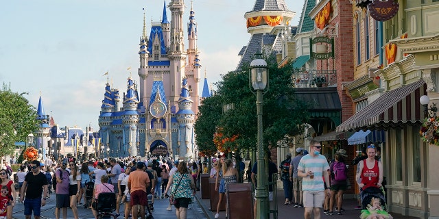 FILE - Guests stroll along Main Street at the Magic Kingdom theme park at Walt Disney World, Lunedi, Ago. 30, 2021, in Lake Buena Vista, Fla. Cooped-up tourists eager for a taste of Florida's sandy beaches, swaying palm trees and warmer climates are visiting the Sunshine State in droves, topping pre-pandemic levels in recent months.