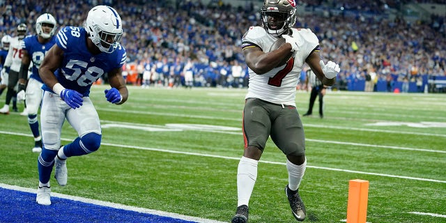The Tampa Bay Buccaneers' Leonard Fournette (7) goes in for a touchdown against the Indianapolis Colts' Bobby Okereke (58) 전반 일요일 동안, 11 월. 28, 2021, 인디애나 폴리스.