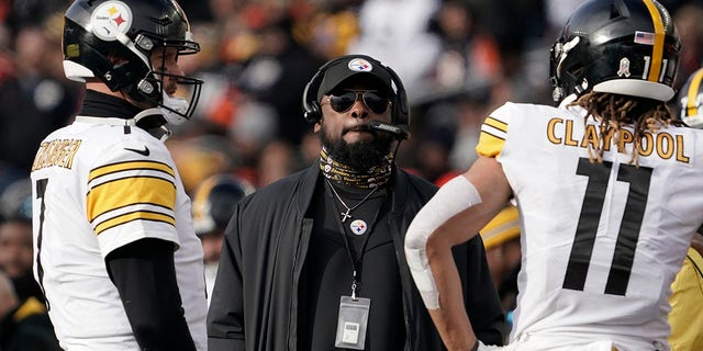 Pittsburgh Steelers head coach Mike Tomlin, center, looks up at the videoboard as he stands with quarterback Ben Roethlisberger (7) and wide receiver Chase Claypool (11) during a timeout during the second half of an NFL football game against the Cincinnati Bengals, Sunday, Nov. 28, 2021, in Cincinnati.