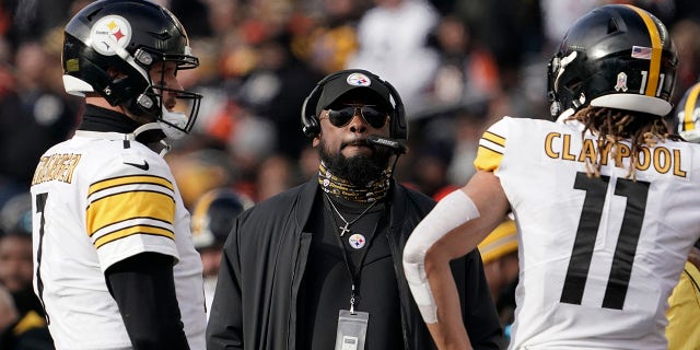 Pittsburgh Steelers head coach Mike Tomlin, center, looks up at the videoboard as he stands with quarterback Ben Roethlisberger (7) and wide receiver Chase Claypool (11) during a timeout during the second half of an NFL football game against the Cincinnati Bengals, Sunday, Nov. 28, 2021, in Cincinnati.