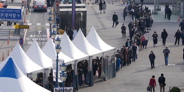 People queue in line to wait for the coronavirus testing at a temporary screening clinic for the coronavirus in Seoul, South Korea, Monday, Nov. 29, 2021. (AP Photo/Lee Jin-man)