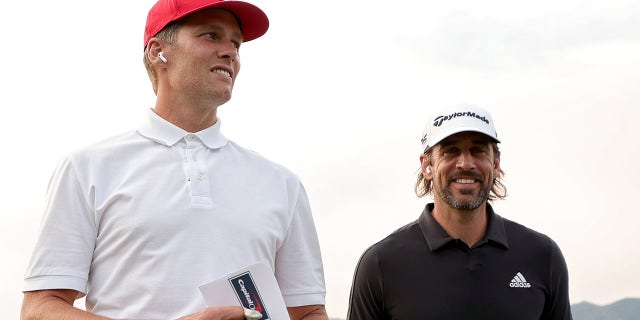 Tom Brady (L) and Aaron Rodgers walk across the course during Capital One's The Match at The Reserve at Moonlight Basin on July 06, 2021 in Big Sky, Montana.