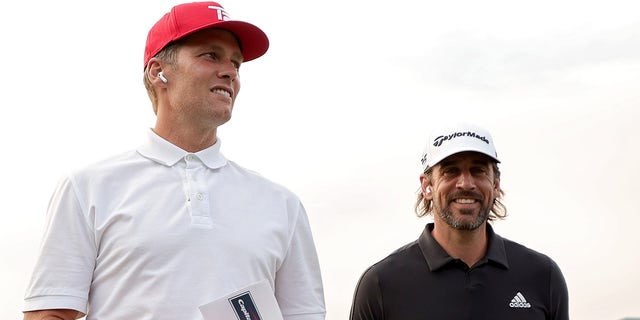 Tom Brady (L) and Aaron Rodgers walk across the course during Capital One's The Match at The Reserve at Moonlight Basin on July 06, 2021 in Big Sky, Montana.