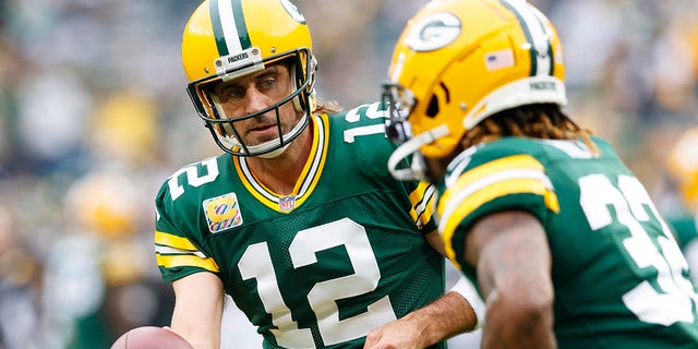 Oct 3, 2021; Green Bay, Wisconsin, USA;  Green Bay Packers quarterback Aaron Rodgers (12) hands the football off to running back Aaron Jones (33) during warmups prior to the game against the Pittsburgh Steelers at Lambeau Field. 