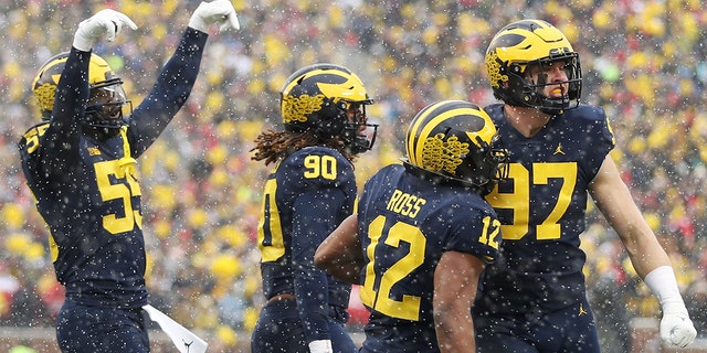 ANN ARBOR, 密歇根州 - 十一月 27: Aidan Hutchinson #97 of the Michigan Wolverines celebrates a sack against the Ohio State Buckeyes with teammates during the first quarter at Michigan Stadium on November 27, 2021 in Ann Arbor, 密西根州.