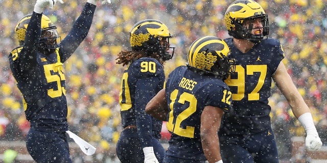 ANN ARBOR, MICHIGAN - 11月 27: Aidan Hutchinson #97 of the Michigan Wolverines celebrates a sack against the Ohio State Buckeyes with teammates during the first quarter at Michigan Stadium on November 27, 2021 in Ann Arbor, ミシガン.