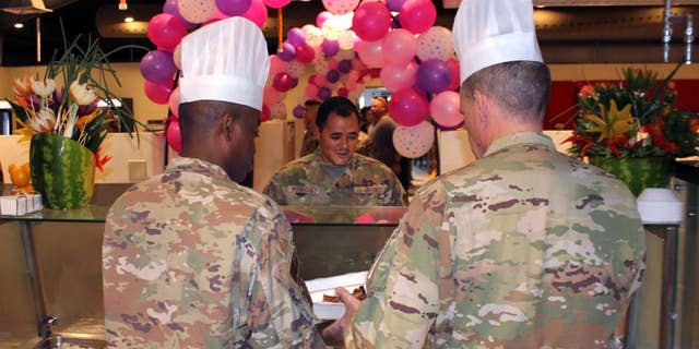 AL DHAFRA AIR BASE, United Arab Emirates - Senior Airman DeMarco Rodriguez joined a group of his fellow Ground Transportation team for a Thanksgiving meal, being served by Chief Master Sgt. Olatokunbo Olopade, command chief for the 380th Air Expeditionary Wing, and Brig. Gen. Andrew Clark, 380th AEW commander, at Al Dhafra Air Base, Nov. 25, 2021. (U.S. Air Force photo by Master Sgt. Dan Heaton)