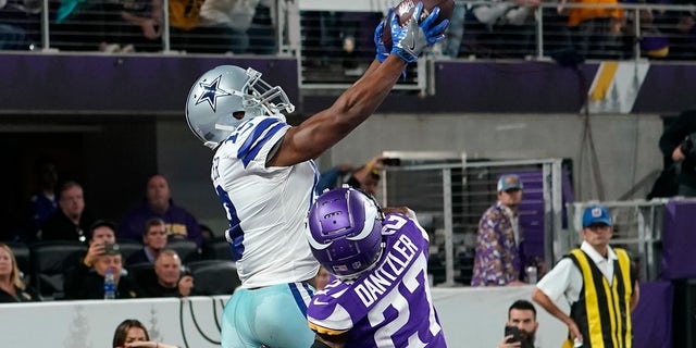Dallas Cowboys wide receiver Amari Cooper (19) catches a 5-yard touchdown pass over Minnesota Vikings cornerback Cameron Dantzler (27) during the second half of an NFL football game, Sunday, Oct. 31, 2021, in Minneapolis. The Cowboys won 20-16.