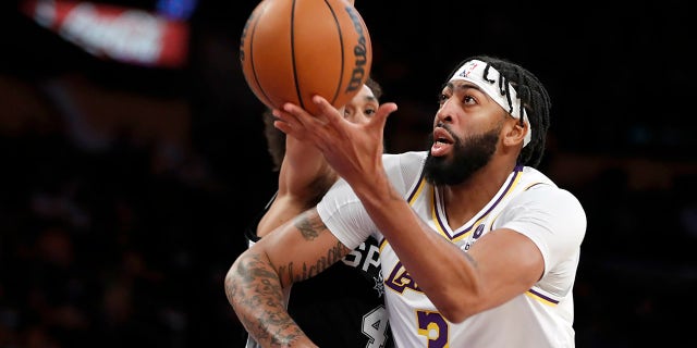 Lakers forward Anthony Davis goes up against San Antonio Spurs guard Derrick White on Nov. 14, 2021, in Los Angeles.