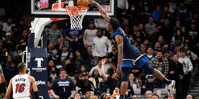 Minnesota Timberwolves guard Anthony Edwards, right, is called for an offensive foul as he leaps over Miami Heat guard Gabe Vincent and dunks the ball while Miami Heat forward Caleb Martin (16) looks on during the second half of an NBA basketball game Wednesday, Nov. 24, 2021, in Minneapolis. The Timberwolves won 113-101.