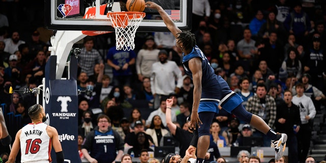 Minnesota Timberwolves guard Anthony Edwards, right, is called for an offensive foul as he leaps over Miami Heat guard Gabe Vincent and dunks the ball while Miami Heat forward Caleb Martin (16) looks on during the second half of an NBA basketball game Wednesday, Nov. 24, 2021, in Minneapolis. The Timberwolves won 113-101.