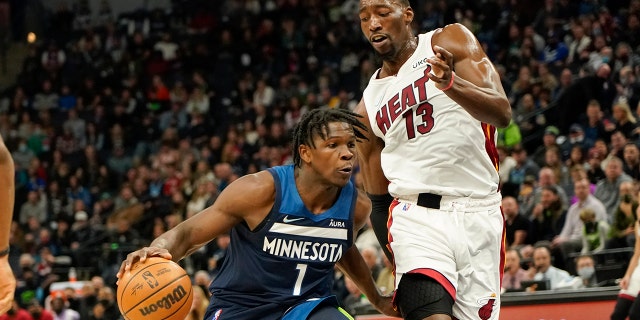 Minnesota Timberwolves guard Anthony Edwards (1) drives past Miami Heat center Bam Adebayo during the first half of an NBA basketball game Wednesday, Nov. 24, 2021, in Minneapolis.