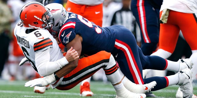 Browns quarterback Baker Mayfield gets dropped by Patriots defensive end Deatrich Wise Sunday, Nov. 14, 2021, in Foxborough, Massachusetts.