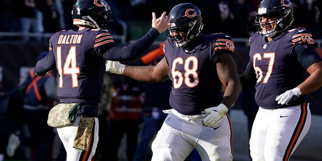 Chicago Bears quarterback Andy Dalton (14) celebrates his touchdown pass tp Darnell Mooney with James Daniels (68) and Sam Mustipher during the second half of an NFL football game against the Baltimore Ravens Sunday, Nov. 21, 2021, in Chicago.