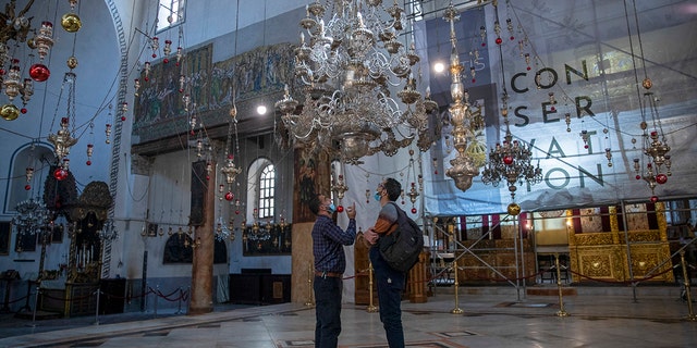 Tourists visit the Church of the Nativity, in the West Bank city of Bethlehem, Tuesday, Nov. 16, 2021.