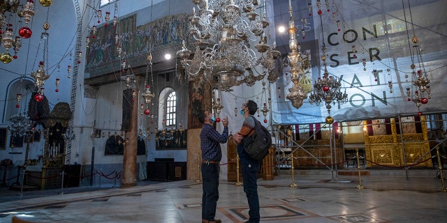 Tourists visit the Church of the Nativity, in the West Bank city of Bethlehem, Tuesday, Nov. 16, 2021.