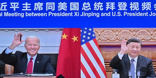 En esta foto publicada por la Agencia de Noticias Xinhua, el presidente chino Xi Jinping, a la derecha, y el presidente estadounidense Biden aparecen en una pantalla mientras se encuentran por enlace de video en Beijing, China, el martes 16 de noviembre de 2021.