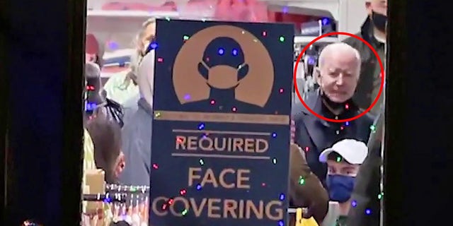 Biden opgemerk sonder masker in die winkel wat maskers benodig