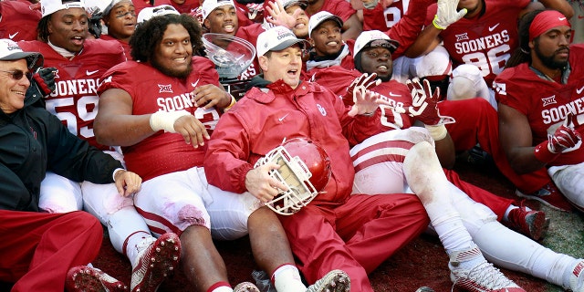 Head coach Bob Stoops of the Oklahoma Sooners poses for photos with the team after their game against the Oklahoma State Cowboys on December 3, 2016 at Gaylord Family-Oklahoma Memorial Stadium in Norman, Oklahoma.